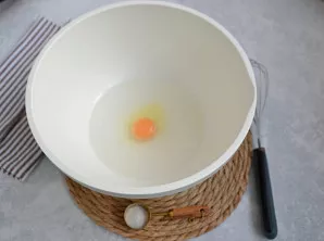 Į dubenį supilkite šaltą vandenį ir įmuškite kiaušinį. Įberkite druskos, išmaišykite šluotele.