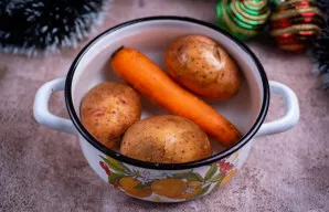 Puode su vandeniu virkite bulves ir morką „su odele“ iki išvirimo.