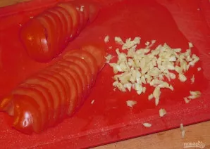 Supjaustykite pomidorus ir susmulkinkite česnaką.
