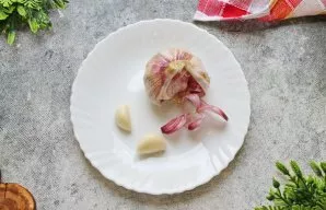 Atskirkite česnako skiltelę, nupjaukite kotelį, nulupkite ir nuplaukite.