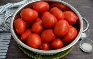 Kruopščiai nuplaukite pomidorus, sudėkite į sietelį ir leiskite vandeniui nuvarvėti.