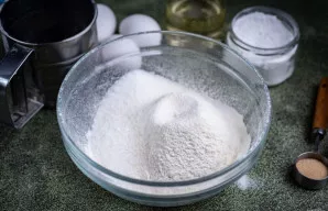 Į dubenį persijokite miltus, įberkite cukraus ir druskos.