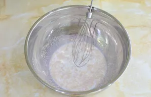 Į dubenį supilkite šiltą pieną ir įberkite druskos bei cukraus.