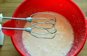 Kiaušinius su cukrumi išplakite iki tirštų, purių putų - apie tris minutes, ne mažiau. Nenustodami plakti, plona srovele supilkite aliejų...