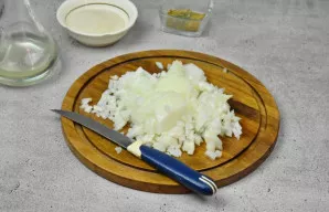 Nulupkite svogūną ir supjaustykite kubeliais.