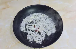 Svogūną nulupkite, smulkiai supjaustykite ir kepkite ant silpnos ugnies 2-3 minutes.