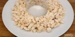 Ant lėkštės (per vidurį) pastatykite stiklinę, o aplink ją sudėkite mėsą ir pasūdykite. Sluoksnį patepkite šaukštu majonezo.