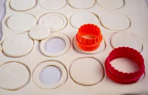 Ant darbo paviršiaus šiek tiek iškočiokite sluoksniuotą tešlą. Naudokite apvalias formeles dviejų dydžių. Didesne formele išpjaukite iš t...