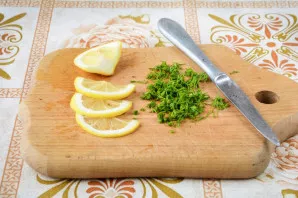 Citriną supjaustykite plonais griežinėliais, o krapus smulkiai supjaustykite peiliu.