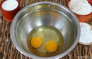 Į dubenį įmuškite kiaušinius ir įberkite druskos. Išplakite šluotele.