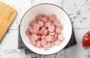 Dešreles supjaustykite griežinėliais ir sudėkite į gilų dubenį.