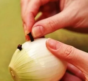 Svogūną nuvalome, įdedame į jį gvazdikėlių. Į puodą suberkite svogūną į veršieną.