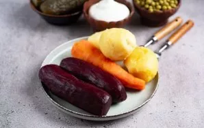 Atvėsinkite virtas daržoves. Nulupkite bulves, burokėlius ir morkas.