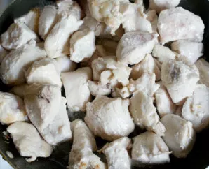 Svogūną atidėkite. Toje pačioje keptuvėje apkepkite vištienos filė gabalėlius. Tada perkelkite filė į lėkštę.