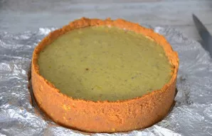 Labai atsargiai nuimkite kepimo žiedą. Pyragą dėkite į šaldytuvą 6–8 valandoms (galite ir nakčiai), kad visiškai sustingtų.