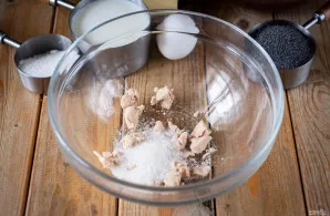 Užpilkite šiltu pienu ir viską aktyviai išmaišykite šluotele, kol mielės visiškai ištirps.