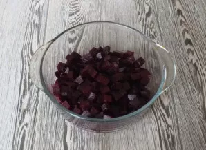 Nuluptus burokėlius supjaustykite vidutinio dydžio kubeliais ir sudėkite į salotų dubenį.