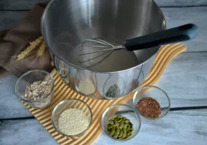 Įberkite linų, sezamų, moliūgų sėklas ir avižinius dribsnius.