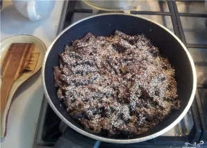Kepame mėsą su svogūnais ant gana stiprios ugnies, kol svogūnai įgauna auksinę spalvą, įberiame sezamo sėklų.