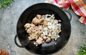 Svogūną supjaustykite pusžiedžiais arba kaip jums patinka ir sudėkite prie mėsos. Česnaką supjaustykite riekelėmis ir įdėkite į katilą. S...