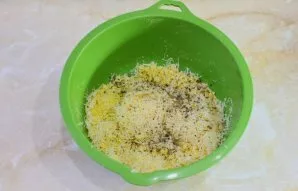 Tada į džiūvėsėlius sudėkite tarkuotą sūrį, druską ir prieskonius. Viską sumaišykite.