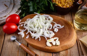 Svogūną nulupkite ir supjaustykite plonais pusžiedžiais. Česnaką taip pat nulupkite ir supjaustykite plonomis riekelėmis.