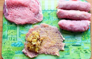 Išmuštą mėsos gabalėlį ištepkite garstyčiomis, rinkitės aštrias. Ant vieno krašto dėkite šaukštą įdaro ir susukite į suktinuką. Pakartoki...