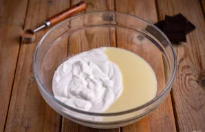 Erdviame dubenyje sumaišykite grietinę ir kondensuotą pieną.