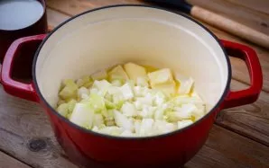 Storadugniame puode ant vidutinės ugnies ištirpinkite 50 gramų sviesto ir sudėkite keturis smulkiai supjaustytus svogūnus.