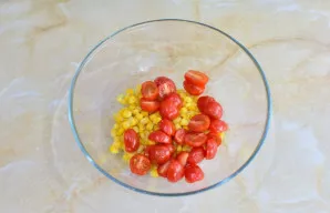 Vyšninius pomidorus perpjaukite į 2-4 dalis ir suberkite į dubenį.