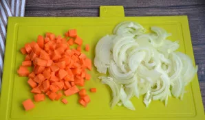 Morką supjaustykite smulkiais kubeliais arba sutarkuokite stambia tarka, svogūną supjaustykite pusžiedžiais.