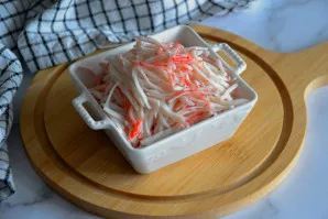 Kol verda kiaušiniai ir daržovės, smulkiai supjaustykite krabų lazdelės arba suplėšykite jas pluošteliais, priklausomai nuo naudojamų kra...