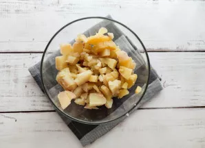 Bulves nulupkite, supjaustykite kubeliais ir pridėkite prie skumbrės.