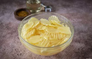 Sudėkite supjaustytas bulves į gilų dubenį ir užpilkite šaltu vandeniu, palikite 5–8 minutes. Tai padės atsikratyti perteklinio krakmolo.