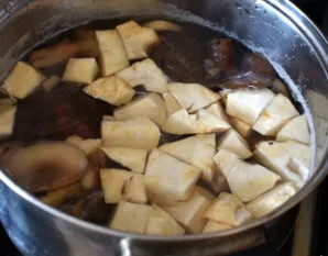 Užvirkite 1,5 litro vandens ir sudėkite į jį grybus, bulves ir salierą. Virkite iki pusiau išvirtų bulvių.