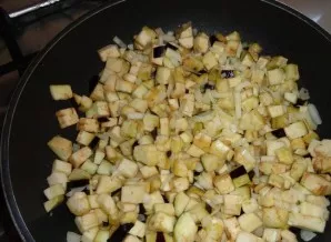 Keptuvėje įkaitinkite augalinį aliejų ir pakepinkite svogūną bei baklažaną.
