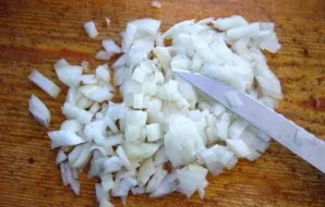 O svogūną smulkiai supjaustome peiliu - nuo jo ir pradėsime gaminimą.