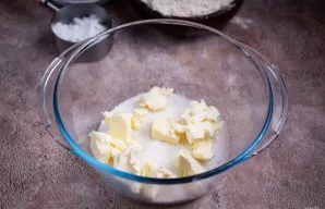 Paruoškite tešlą. Į dubenį sudėkite minkštą sviestą ir cukrų.