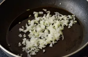 Svogūną smulkiai supjaustykite, tuomet apkepkite keptuvėje iki auksinės spalvos.