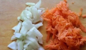 Nulupkite svogūną, nuplaukite ir nulupkite morką. Supjaustykite svogūną kubeliais. Morkas sutarkuokite stambia tarka.