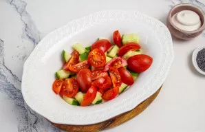 Vyšninius pomidorus supjaustykite į 2-4 dalis, priklausomai nuo jų dydžio, ir sudėkite į salotinę.