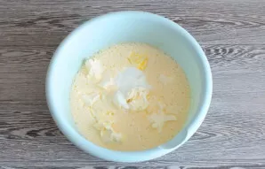Į kiaušinių mišinį įdėkite minkšto margarino ir grietinės. Dar kartą išplakite.