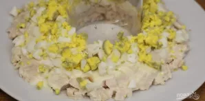 Kiaušinį nulupkite, supjaustykite ir sudėkite ant mėsos. Pasūdykite ir sluoksnį patepkite šaukštu majonezo.