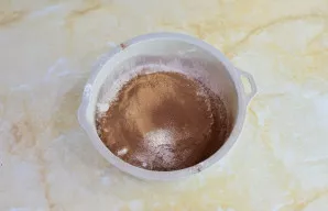 Per sietelį persijokite miltus ir kakavą. Įdėkite sodą.