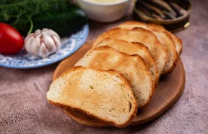 Duonos riekeles šiek tiek paskrudinkite skrudintuve arba ant sauso keptuvės iki lengvo auksinio atspalvio.