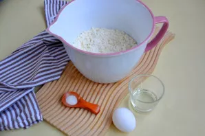 Į tešlą įdėkite įmuškite kiaušinį, druską ir vandenį.