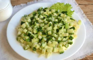 Aptepkite bulvių sluoksnį majonezu, ant viršaus dėkite smulkiais kubeliais supjaustytą agurką. Šį sluoksnį taip pat patepkite majonezu.