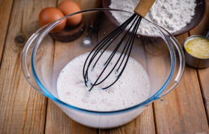 Užpilkite šiltą pieną ir šluotele aktyviai išmaišykite šiuos ingredientus, kol ištirps cukrus ir mielės.