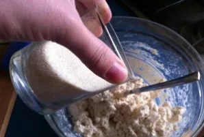 Į varškę įmaišykite manų kruopas ir vanilę.