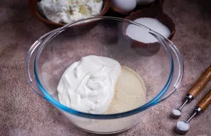 Erdviame dubenyje sumaišykite grietinę ir manų kruopas.